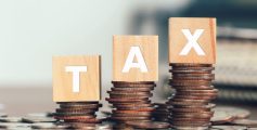 tax-concept-with-wooden-cubes-with-word-tax-stacked-coins-1-scaled